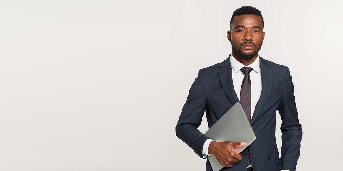 Man with a high-paying career in a suit holding a laptop