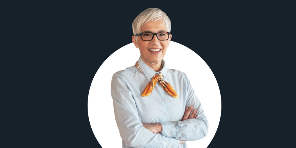 A woman with glasses, arms crossed smiling