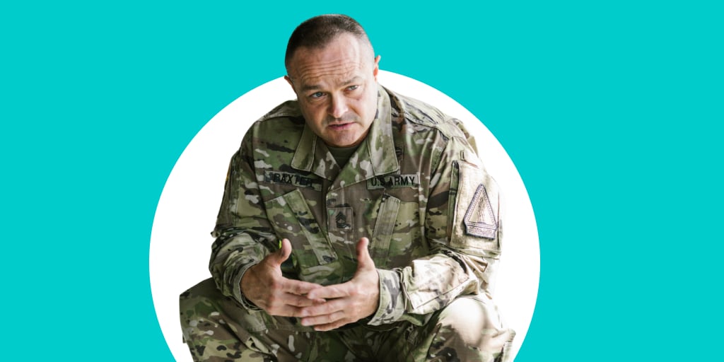 Soldier in uniform, sitting and hunched over as he explains something