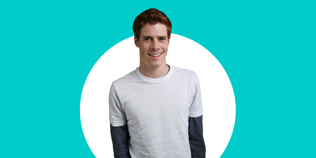 A young adult in a white shirt smiling at the camera
