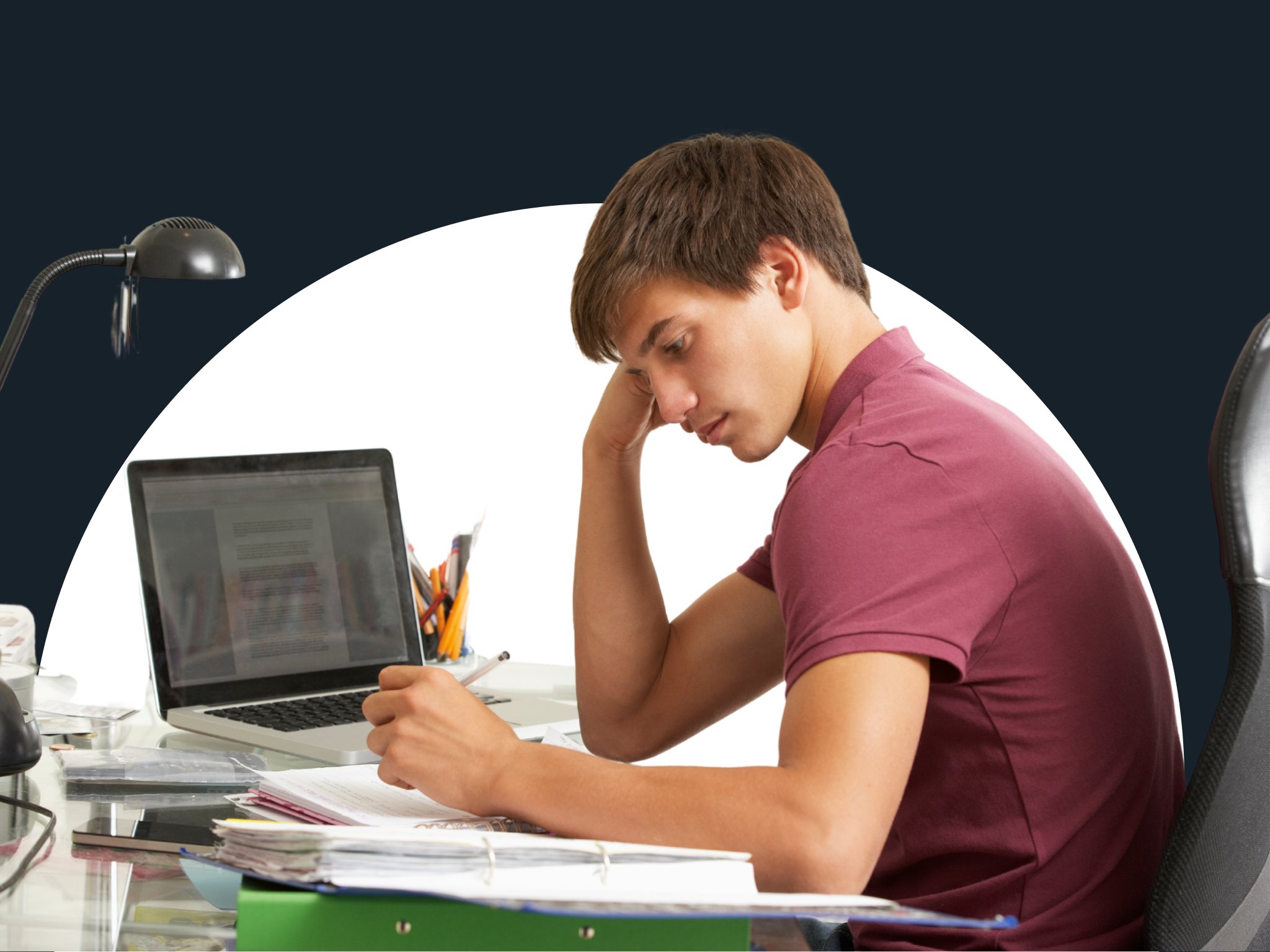 A young man writing and working as he takes notes from a laptop