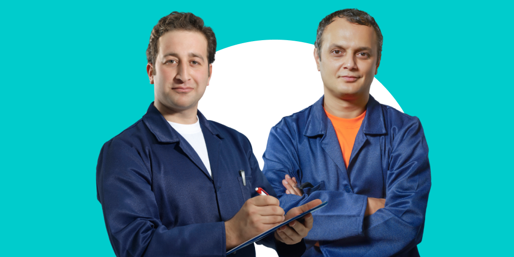 Two blue collar workers standing near each other smiling