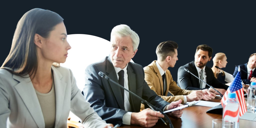 Group of office professionals well-dressed and around a meeting table having conversations