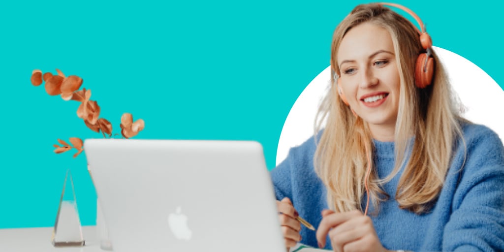 A female worker with headphones on in front of a computer working