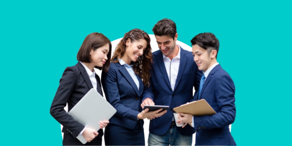 A group of young adults in suits working on a table together