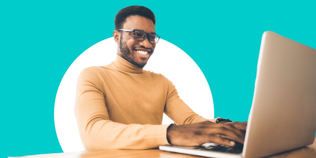 A young man working on a laptop sitting down