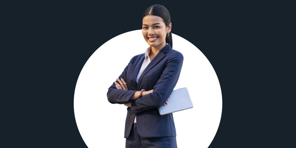 A woman dressed in a suit holding as piece of paper with her arms crossed