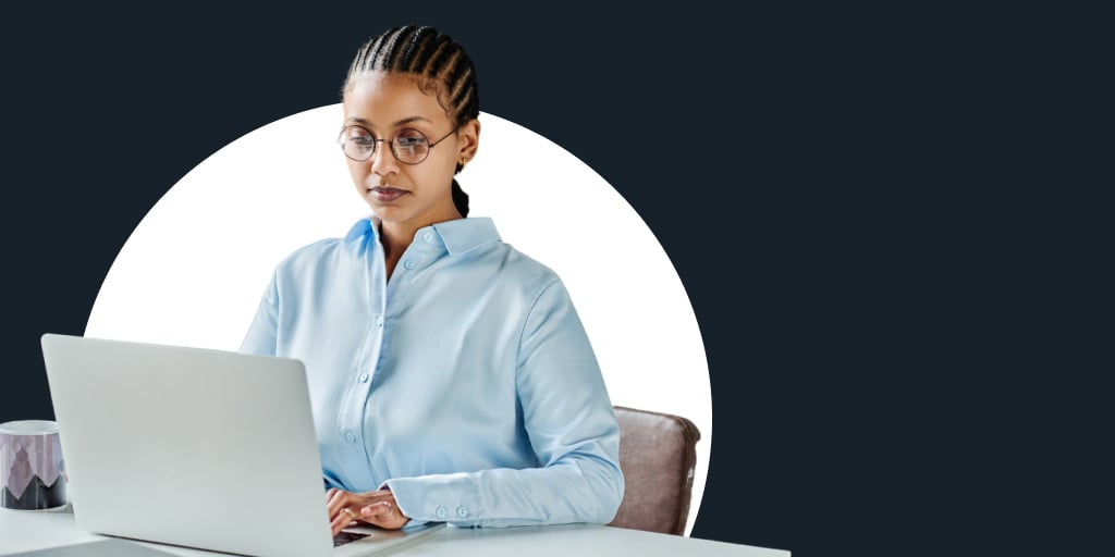 A working sitting at a desk while on a laptop computer