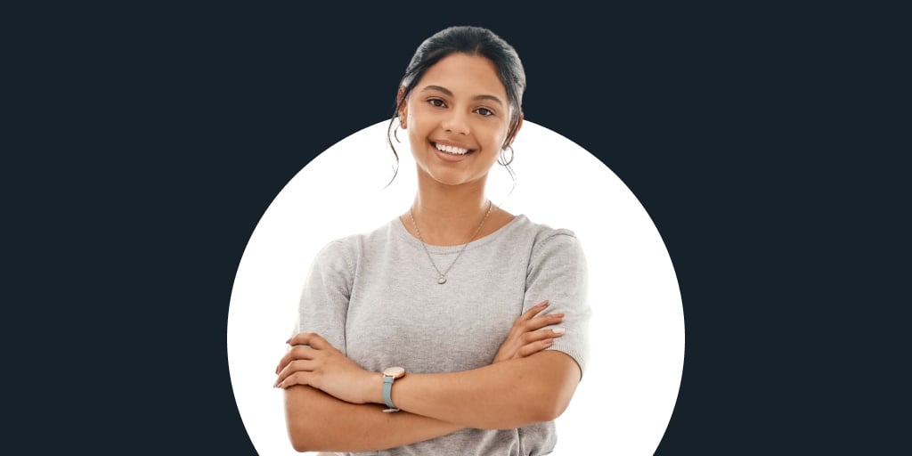 A young woman with arms crossed smiling