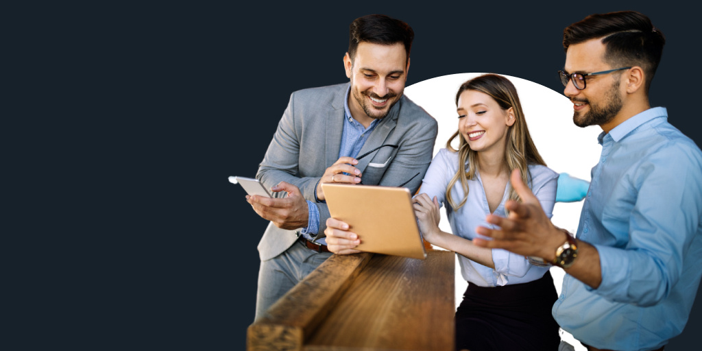 A teacher in a suit working with and assisting a student working on a laptop