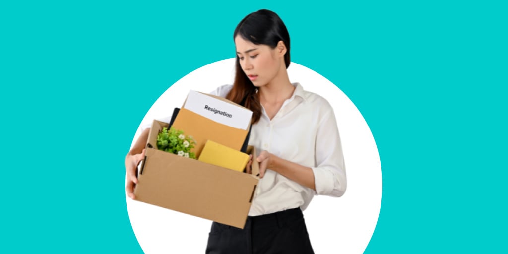 A worker who has received a layoff carrying her things out in a box