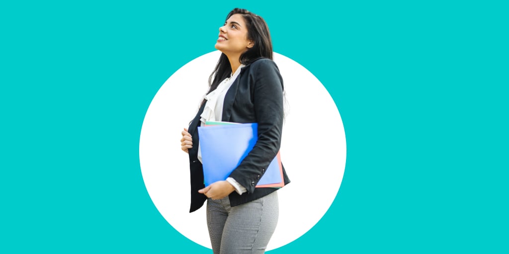 Young adult carrying a folder and walking confidently forward
