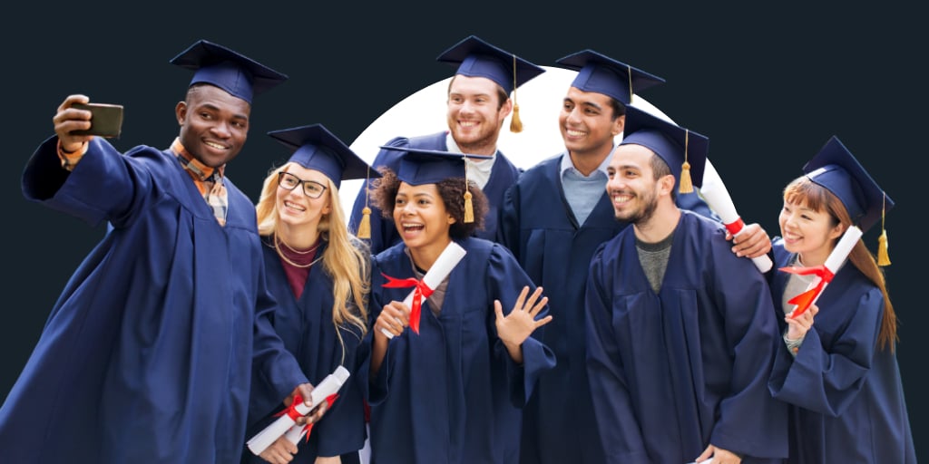 Group of students in cap and gowns celebrating as they're handed their degrees