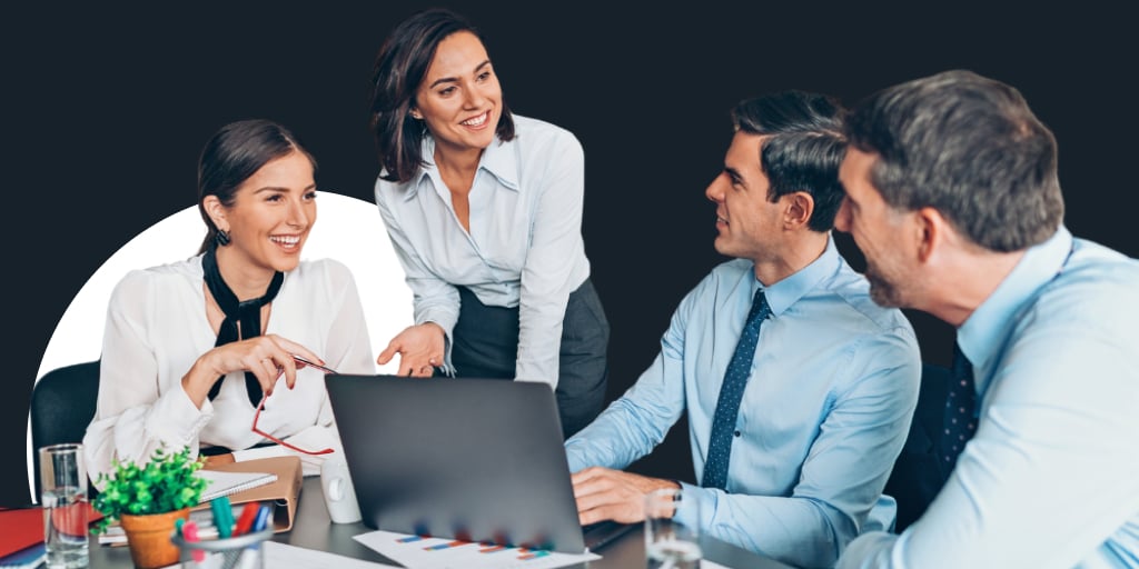 Group working around a conference table, one person a laptop taking notes