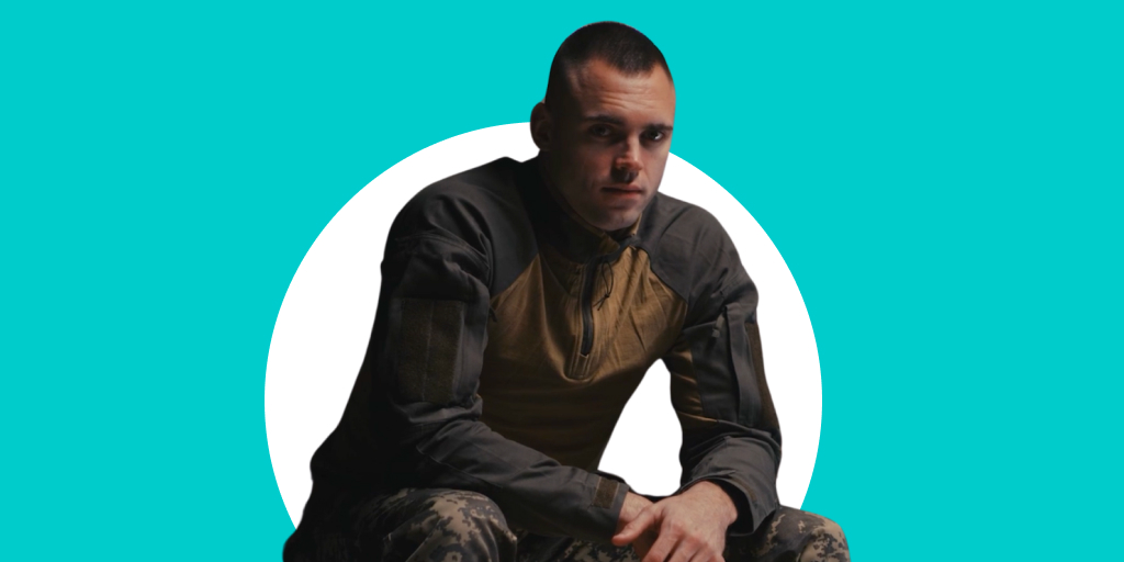 A solider in fatigues sitting casually with arms crossed