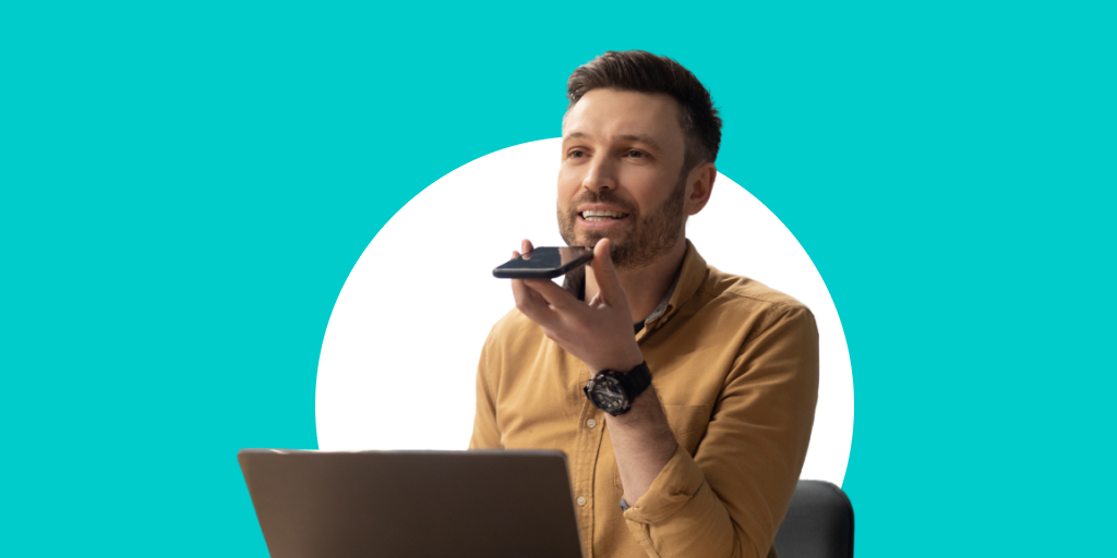 A worker in front of a laptop while talking into a phone held in front of them