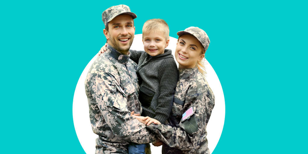 Two soldiers wearing camouflage with a child in-between them that they're holding together