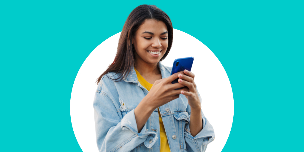 A young adult smiling and texting on their phone