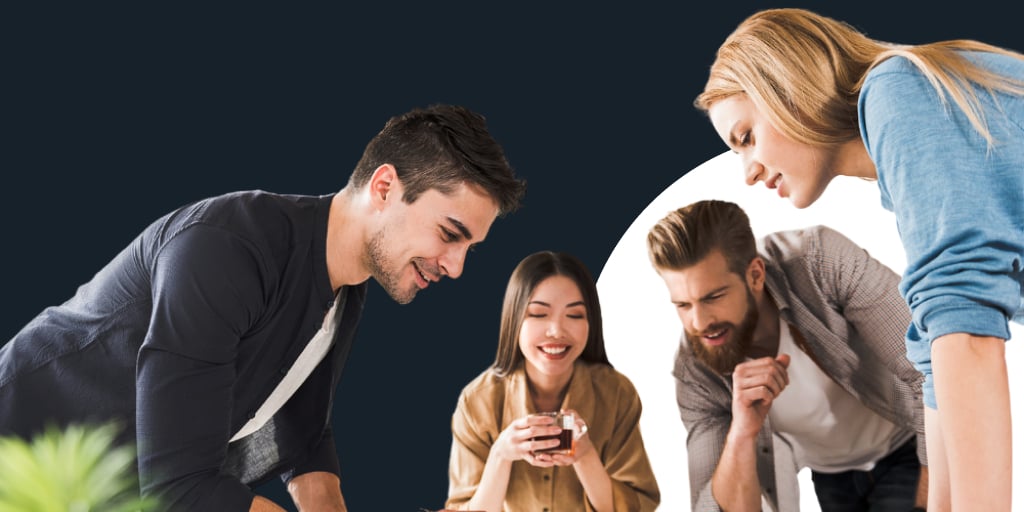 A group of professionals all leaning around a table, some on phones or devices as they work collaboratively