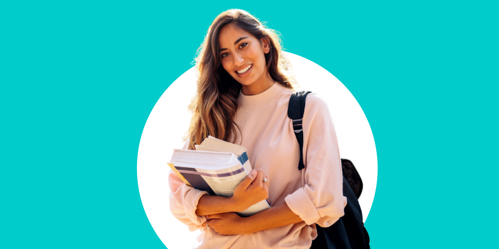 A student holding books and supplies with a backpack as they walk