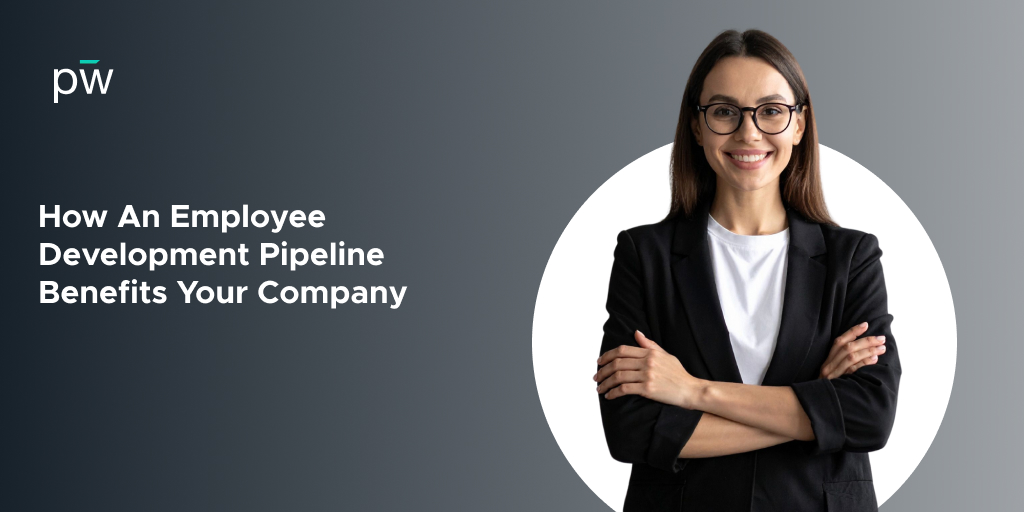 A woman in glasses stands smiling, arms crossed