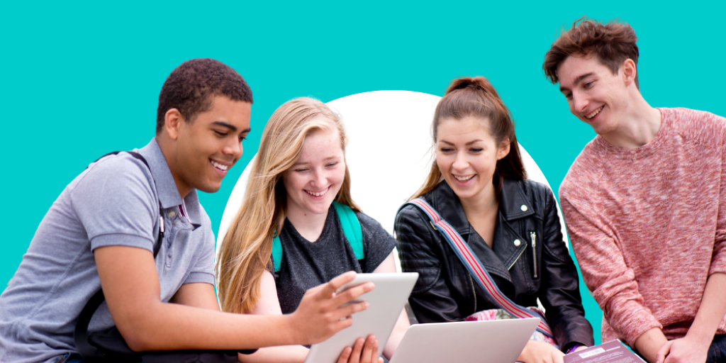 A group of young adults gathered around a table with backpacks and other school supplies. They're working on computers and tablets.