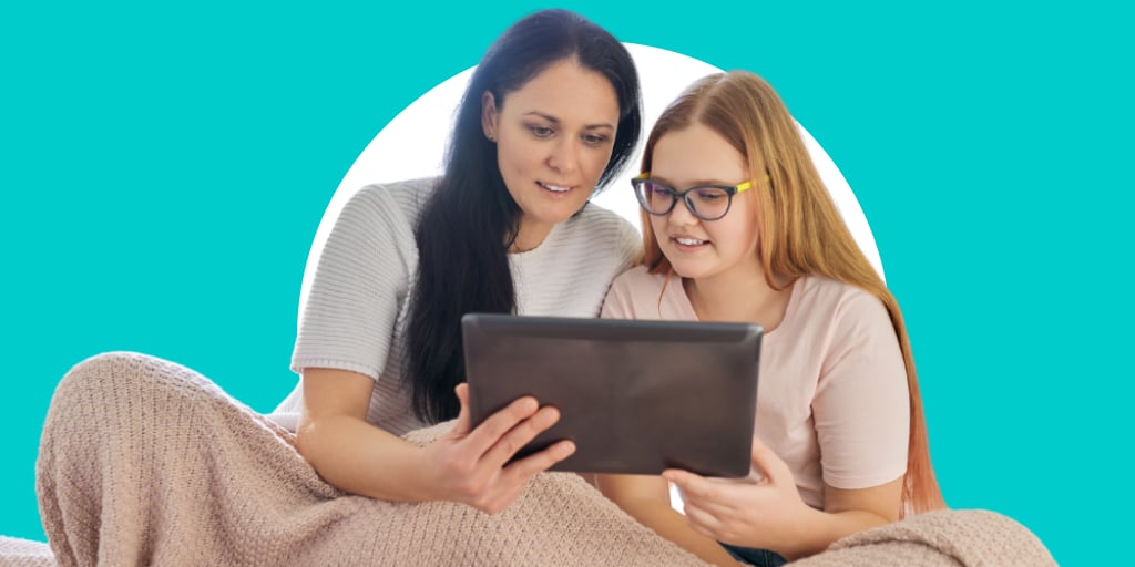 An older woman working with a younger woman on a laptop as they sit next to each other