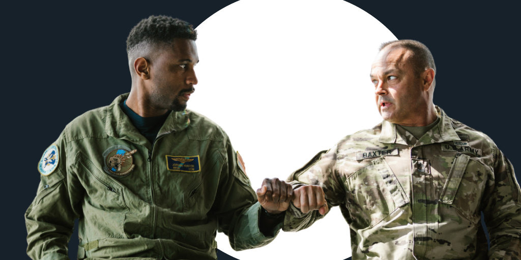 Two male military soldiers looking at each other and fist bumping eachother